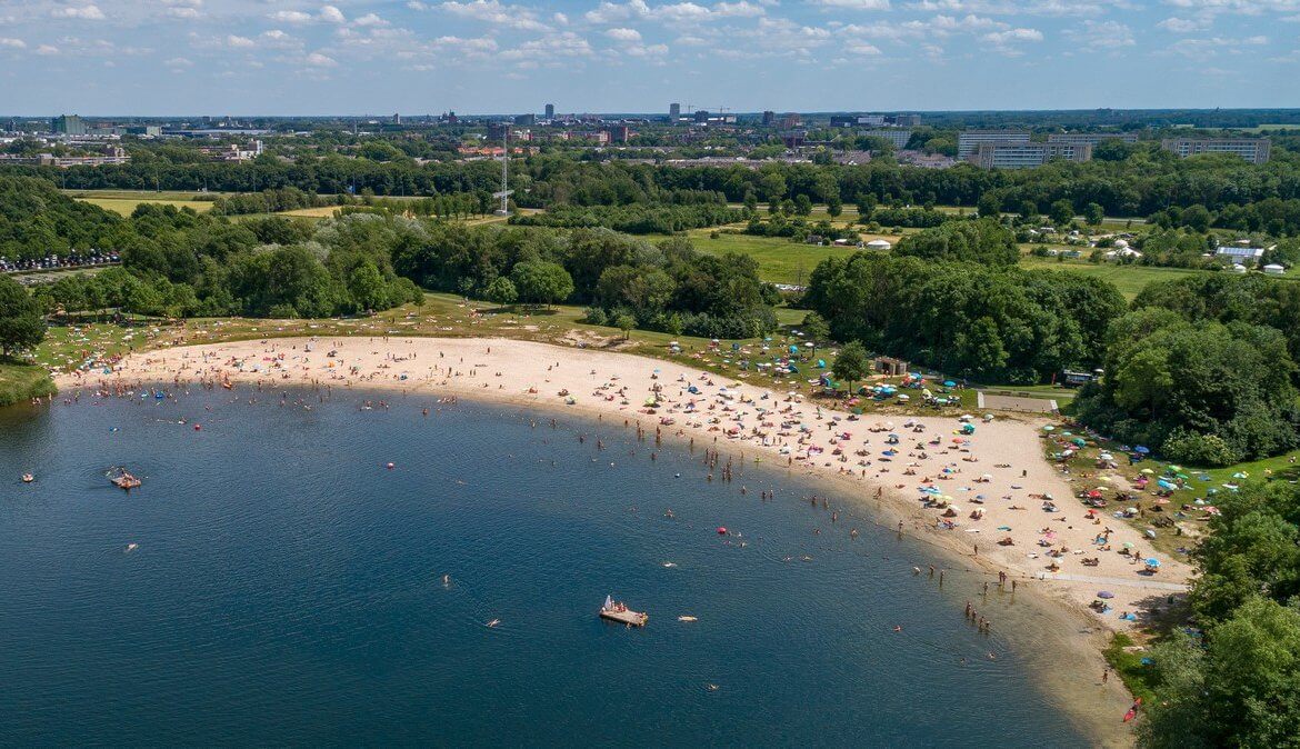 Luchtfoto van mensen die verkoeling zoeken in en op het water.