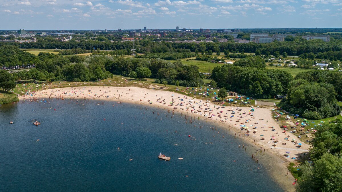 Luchtfoto van mensen die verkoeling zoeken in en op het water.