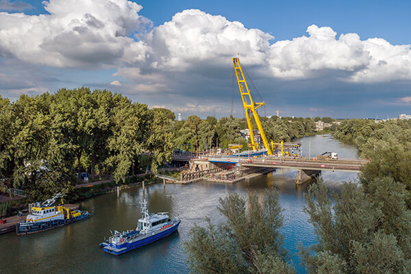 Dronefoto van een enorme hijskraan die een deel van een brug in Dordrecht hijst